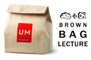 brown paper sack folded at the top with the UM Logo on the front. Text to the right reads "Brown Bag Lecture"