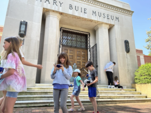 Summer 2023 Fantastic Storyteller Campers during their Morning Photo Excursion to the 1939 Mary Buie Museum historic portico entrance.